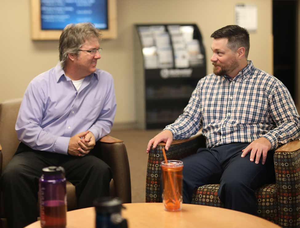 Two people chatting in campus common area