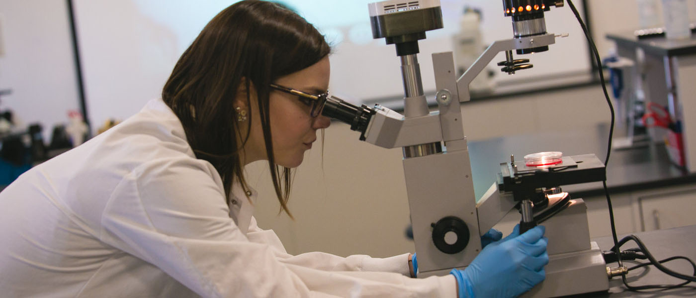 Female Student Looking into Microscope NWTC